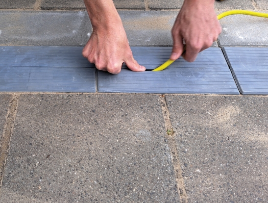 Grijze EV-kabelgoottegel